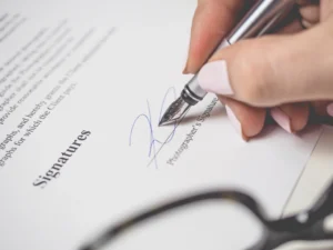 Cliente firmando un contrato tras recibir asesoramiento jurídico