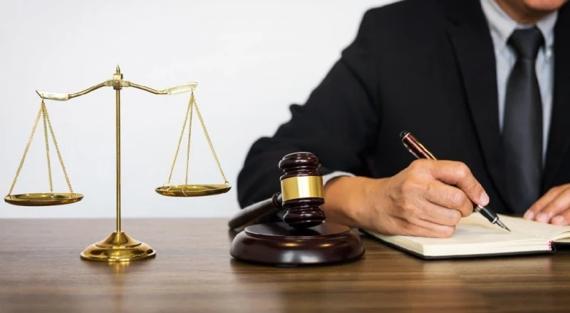 Despacho de abogados en Valencia: balanza de la justicia y abogado firmando documentos